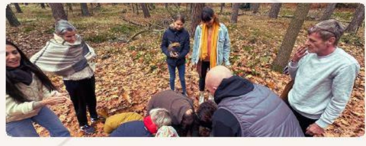 Guides et participants rassemblés en forêt pendant une retraite Renaissance, plusieurs personnes accompagnent une participante assise au sol