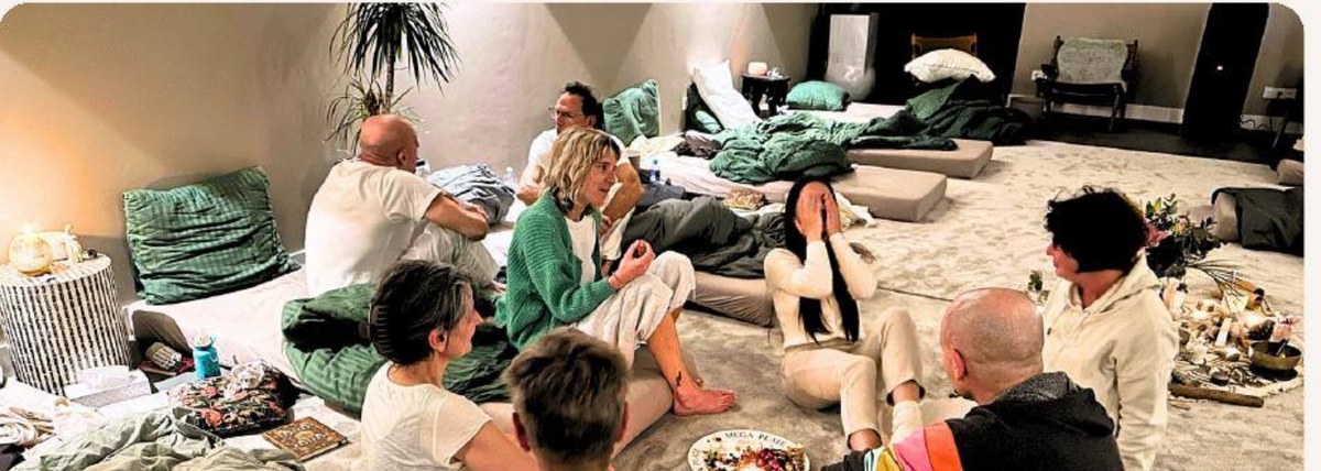Participants assis en cercle sur des coussins pendant un cercle de partage, lors d'une retraite Renaissance à Mierlo